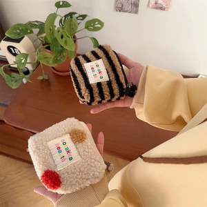 Detail of plush lamb-like fabric and zipper on mini striped and polka dot makeup bags