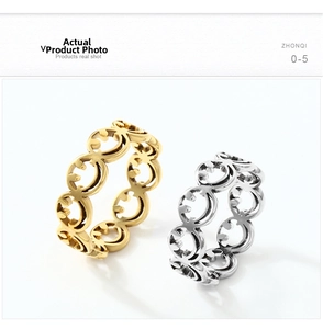 Detail shot of laser-cut smiley face patterns on gold and silver stainless steel rings