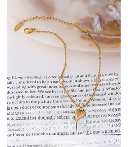 Detail of 18k gold plated titanium heart anklet with zircons and beaded chain