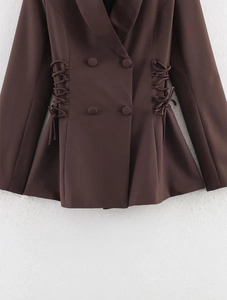 Detail view of dark brown double-breasted blazer featuring waist drawstring lacing ties