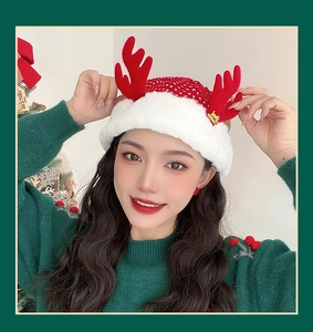 Detail of red knit Christmas hat with white faux fur trim and gold Merry Christmas pendant