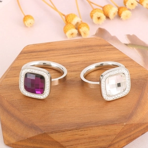 Detail of 18K gold-plated stainless steel rings with square purple and clear crystals