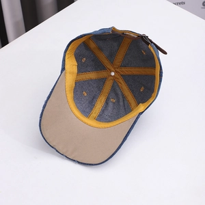 Internal detail of denim baseball cap with yellow reinforcement strips and leather strap