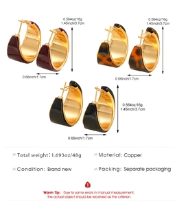 Close-up of wide C-shaped hoop earrings set in burgundy, tortoiseshell, and glossy black
