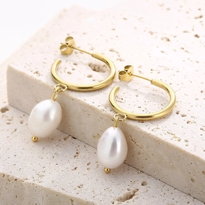 Détails macro de boucles d'oreilles en or 18 carats avec perles poires sur pierre