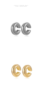 Detail of silver smooth and gold hammered texture C-shaped ear cuffs set on white background