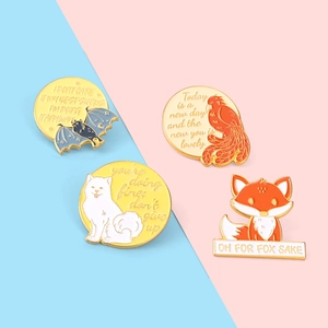 Détail de quatre pins en émail avec citations motivantes et animaux sur fond pastel