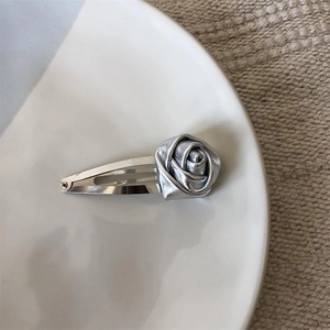 Elegant silver metal hair clip featuring a 3D rose design on a ceramic plate