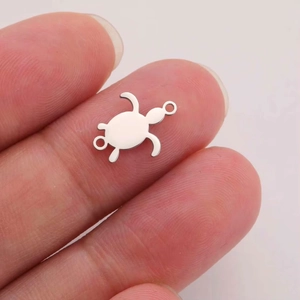 Miniature 304 stainless steel sea turtle pendant for DIY jewelry making shown on fingertips