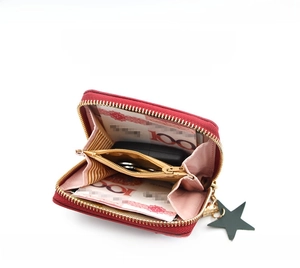 Detailed interior of red wallet with accordion slots, star tag, and pink lining