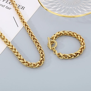 Detail of golden stainless steel Cuban link necklace and bracelet set with T-bar clasp