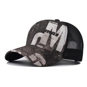 Close-up of mesh trucker hat with gradient gray print and embroidered letter M