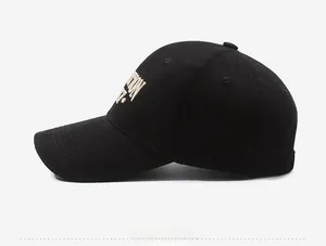Detail of premium black cotton baseball cap showing yellow 3D letter embroidery and stitching