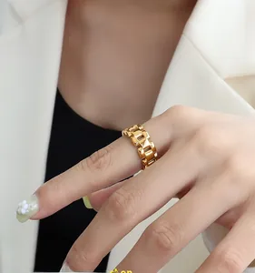 Detailed close-up of a stylish 18k gold chain-link ring on a fashion model hand