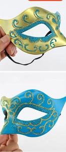 Detail view of intricate gold glitter patterns on elegant blue and gold masquerade masks