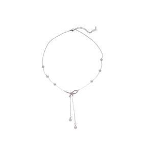 Silver bow necklace with sparkling crystals and pearl pendant on a white background
