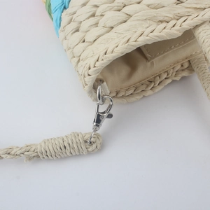 Detail of hand-woven straw bag texture with metallic lobster clasp and sturdy woven strap