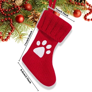 Knitted Christmas stocking with white paw print pattern and product size dimensions