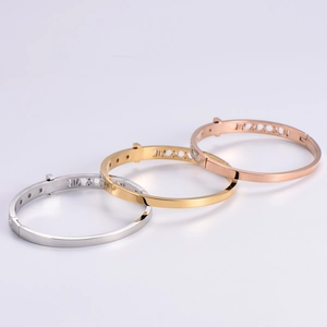 Three hollow Roman numeral bracelets in silver, gold, and rose gold with diamond accents