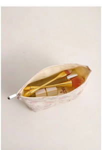 Macro view of open floral canvas makeup bag showing interior space and zipper