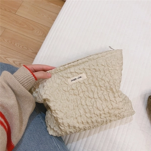 Détail de la trousse de maquillage plissée crème avec étiquette simple wish et fermeture éclair