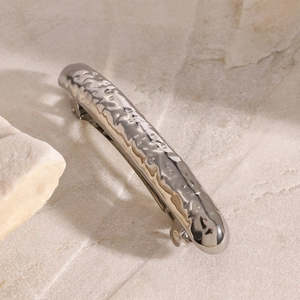 Detailed macro view of silver stainless steel hair clip with hammered metal texture finish