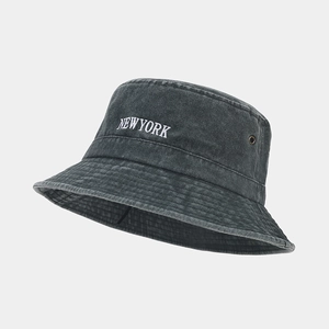 Macro shot of white NEW YORK embroidery on dark gray washed denim bucket hat with metal eyelets