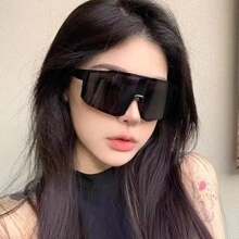 Front view of a woman wearing oversized black shield sunglasses for outdoor sports