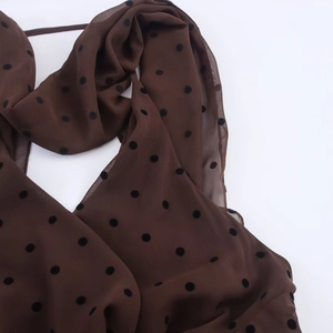Detailansicht des dunkelbraunen Polka-Dot-Chiffonkleids mit halbtransparentem Stoffgewebe