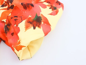 Details des roten Aquarell-Blumendrucks auf elegantem gelbem Sommerkleid aus Chiffon