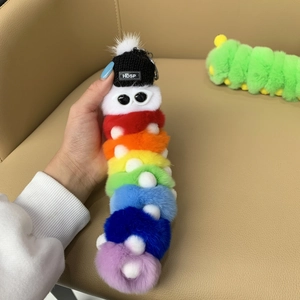 Detailed close-up of rainbow plush caterpillar keychain with colorful fur and black knitted hat
