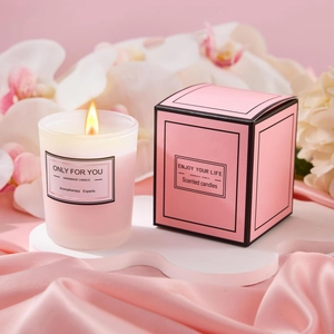 Close-up of handmade aromatherapy candle in frosted glass with a pink floral gift box