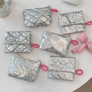 Detail of silver quilted cosmetic bag with heart patterns and pink zipper pullers