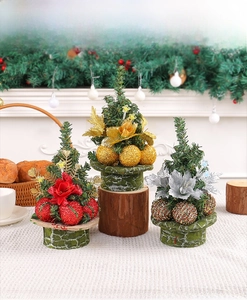 Close-up of three mini Christmas trees with glitter balls on green top hat bases