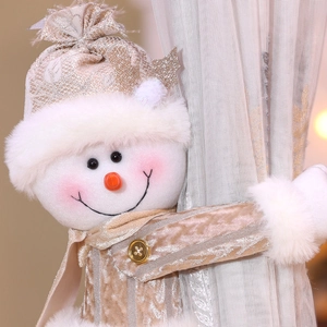 Detail of plush snowman curtain tieback with sequin hat and carrot nose on fabric