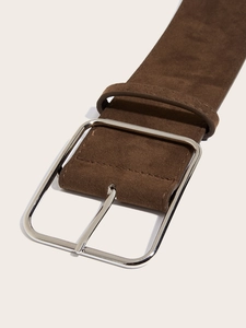 Close-up of brown suede wide waist belt with a large vintage silver square buckle detail