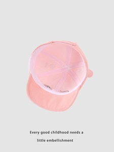Détail de l'intérieur d'une casquette bébé montrant le bandeau et la boucle réglable