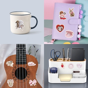 Waterproof coquette stickers featuring bows and cats applied to a mug and notebook