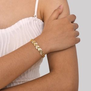 Detailansicht eines Blattarmbands in Gold mit Zirkonia, getragen am Handgelenk eines Models