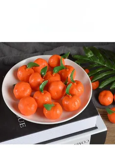 Macro shot of realistic PVC mini oranges with green leaves on a white ceramic plate