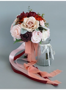 Close-up of artificial bridal bouquet with champagne roses and flowing silk ribbons