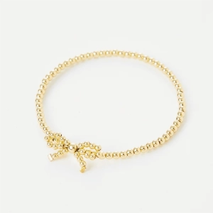 Bracciale di perle placcato oro 18K fatto a mano con fiocco su sfondo bianco puro