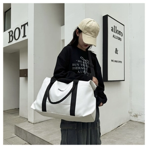 Detail of large white oxford fabric fitness bag with black straps and XHUA logo