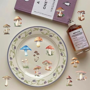 Flat lay of vintage mushroom stickers on a ceramic plate with decorative props