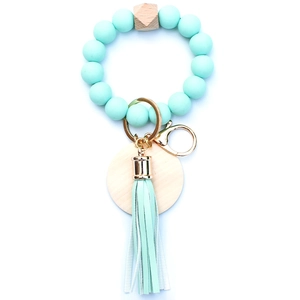 Close-up of mint green silicone beads and natural wood bead on keychain with tassel