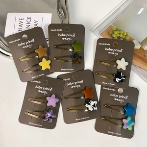 Set of 12 star-shaped acetate hair clips with diverse colorful patterns and metallic base
