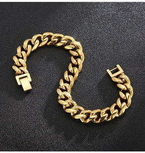Macro shot of gold-plated 9mm cuban link chain bracelet on a black matte background