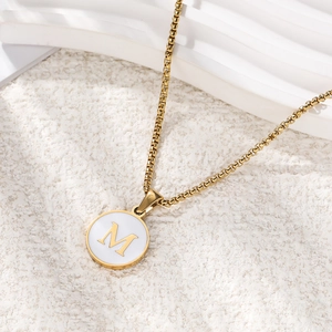 Minimalist gold O-chain necklace featuring a white round pendant with letter M charm