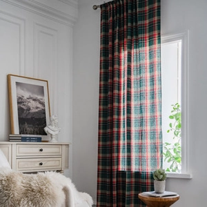 Detailed texture of green and red plaid linen-style fabric with elegant ruffled edges