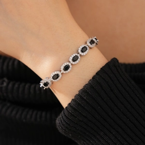 Macro detail of oval black zircon bracelet with shimmering silver metal and micro-pave setting